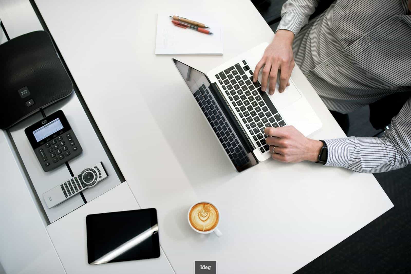 person using laptop on white wooden table