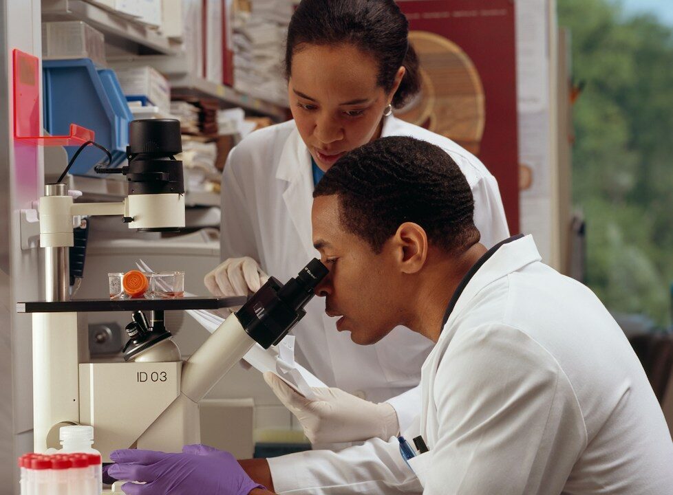 Dos investigadores trabajando con un microscopio en un laboratorio